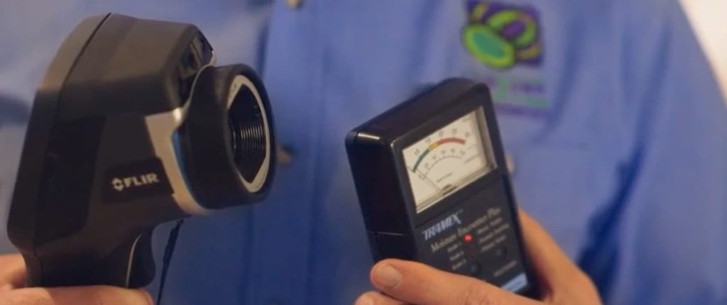 Photo of a Conquer Termites inspector holding a moisture meter and a thermal detection camera