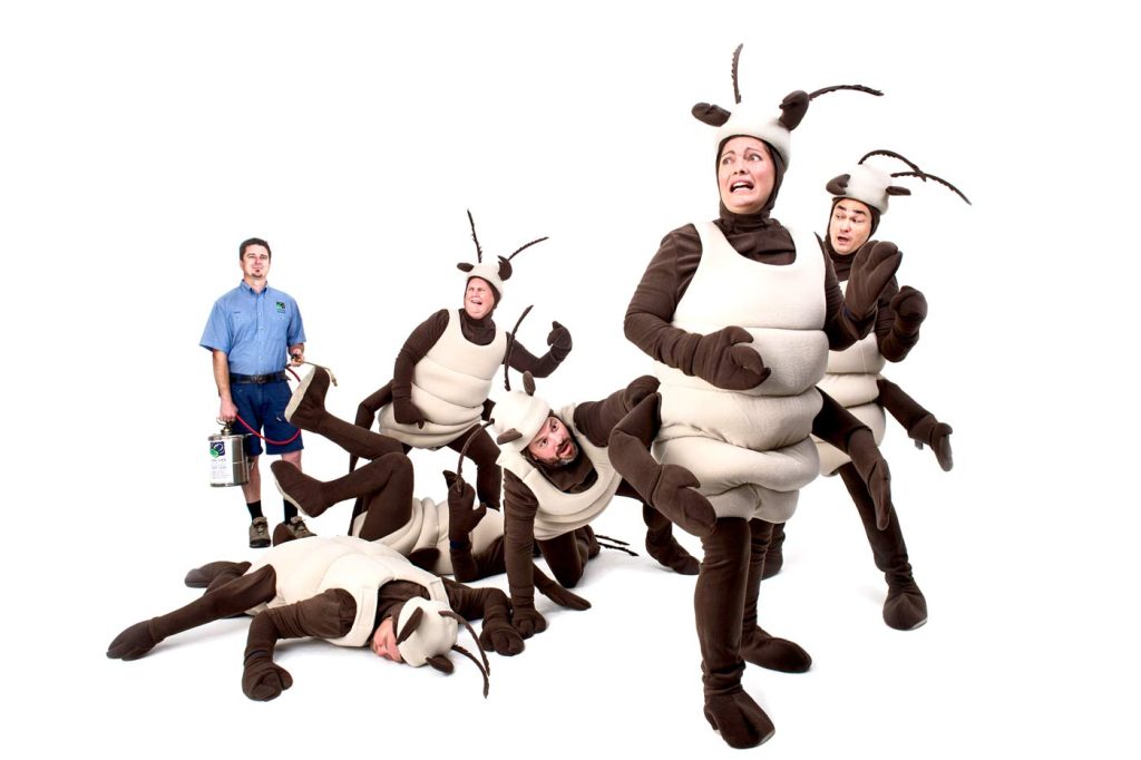 A photo of Conquer Termites staff in termite costumes looking scared and running away from a pest controler